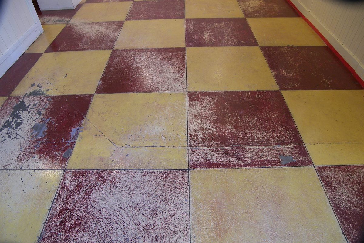 Worn checkerboard floor before refinishing